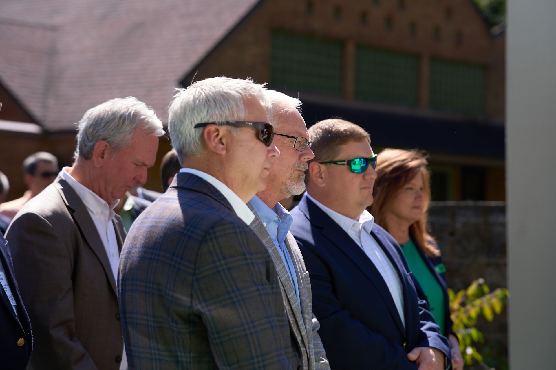 A group of men in suits and sunglasses are standing in a line.