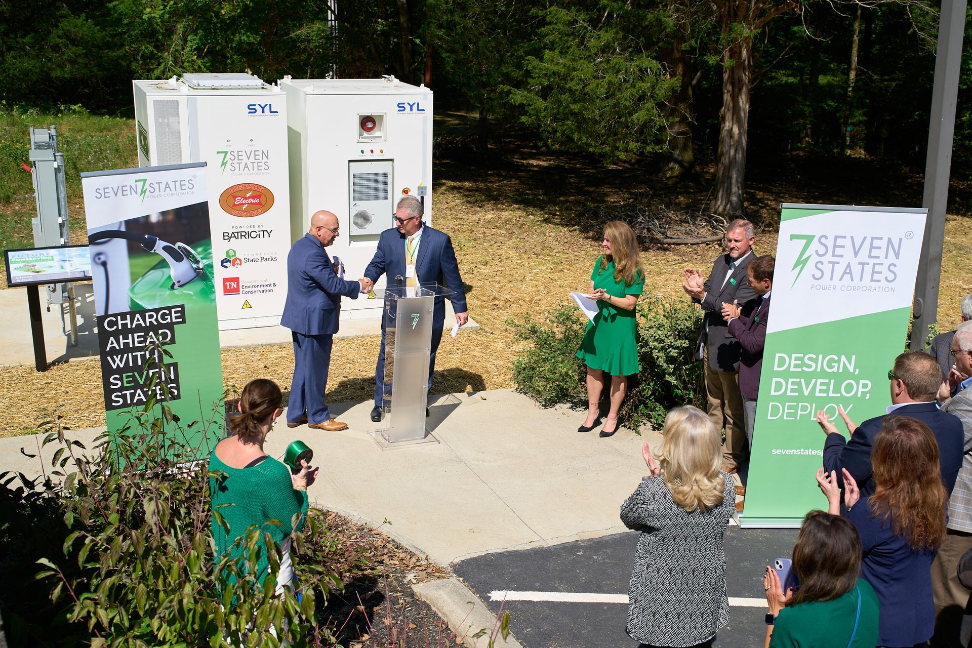 A group of people standing around a podium with a sign that says seven states