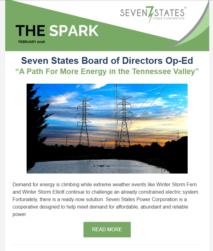 A white shipping container is sitting on top of a lush green field next to solar panels.