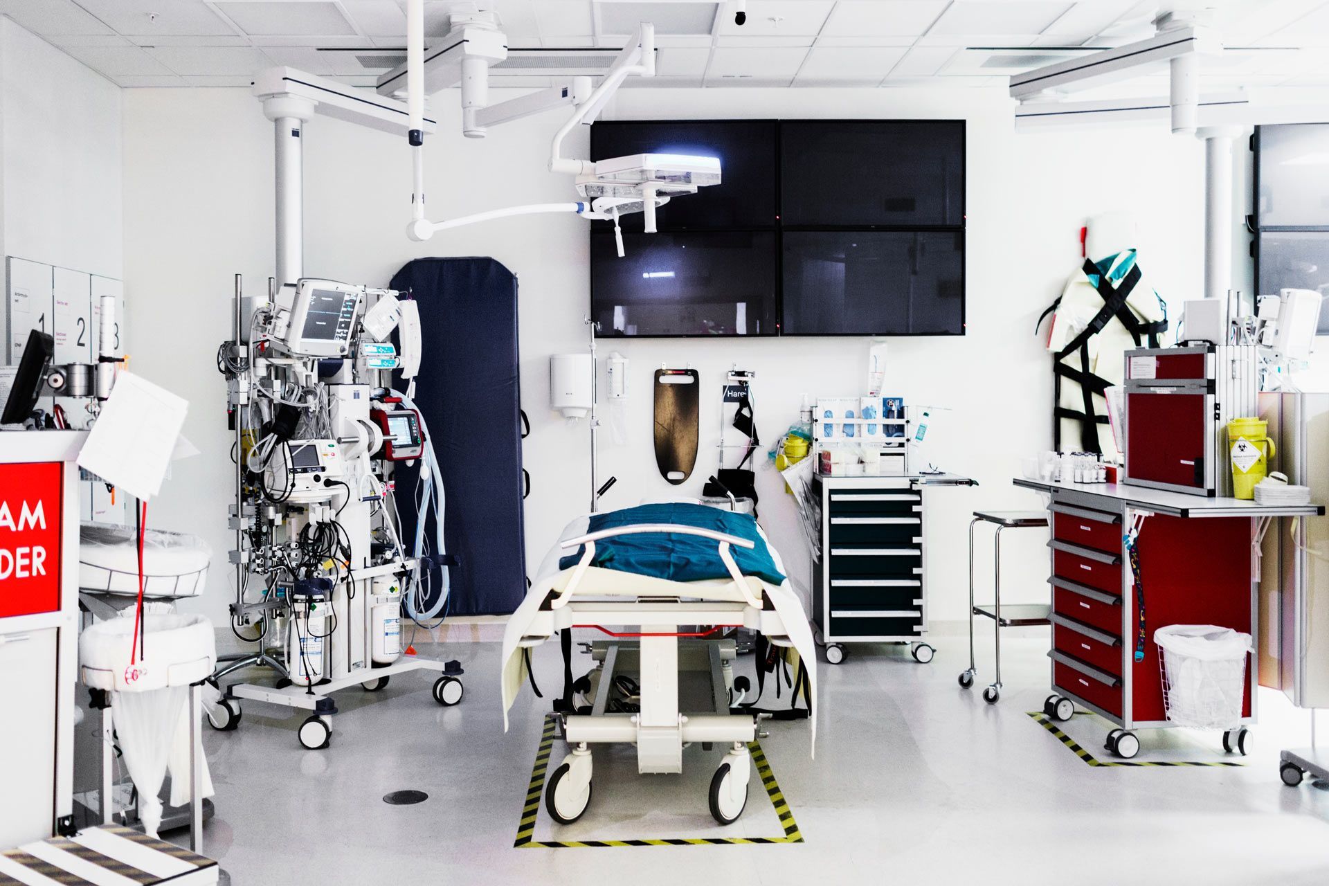 An empty hospital bed at an intensive care unit surrounded by various medical equipment. An empty hospital bed at an intensive care unit surrounded by various medical equipment.
