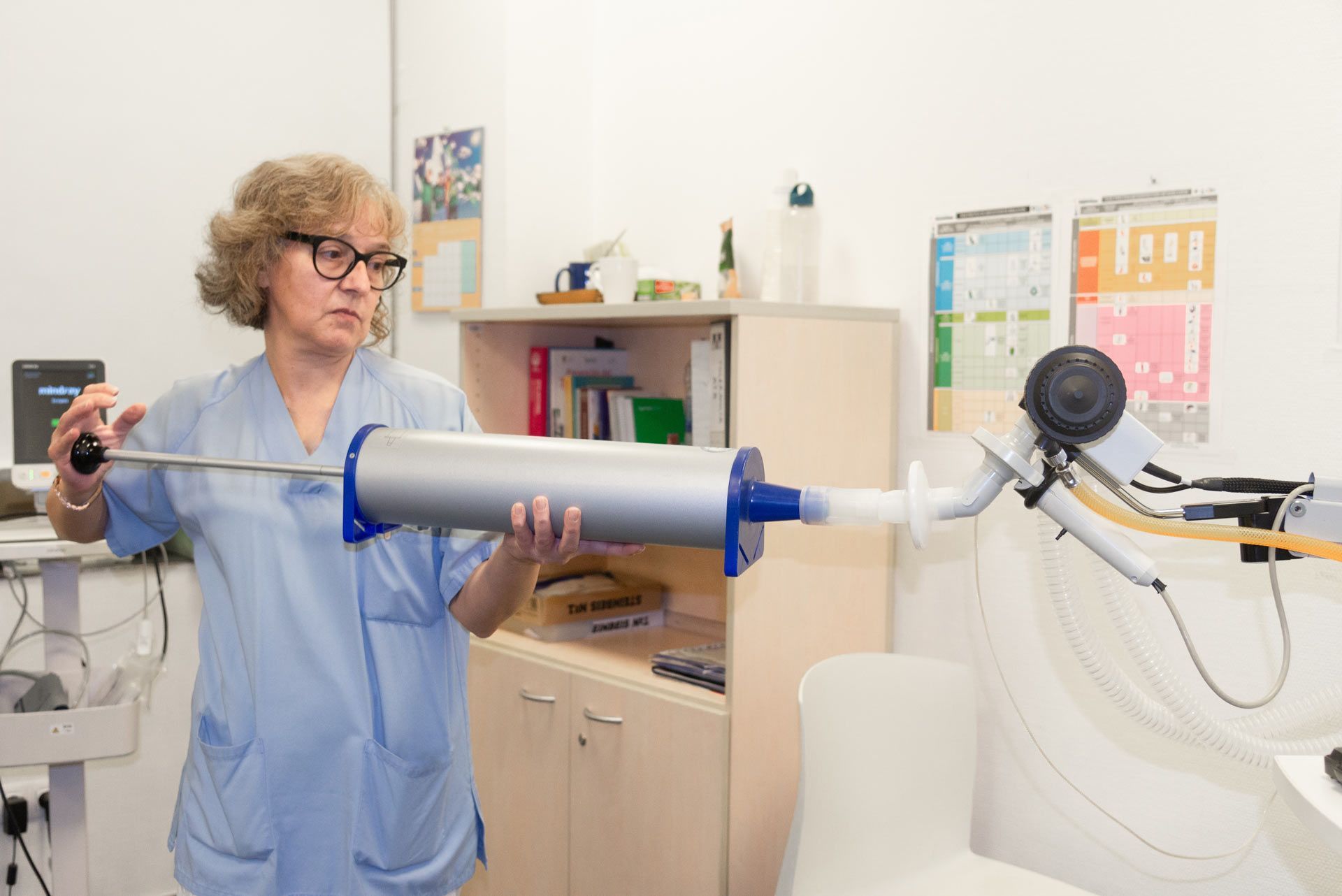 Female medical professional holding a spirometry machine.