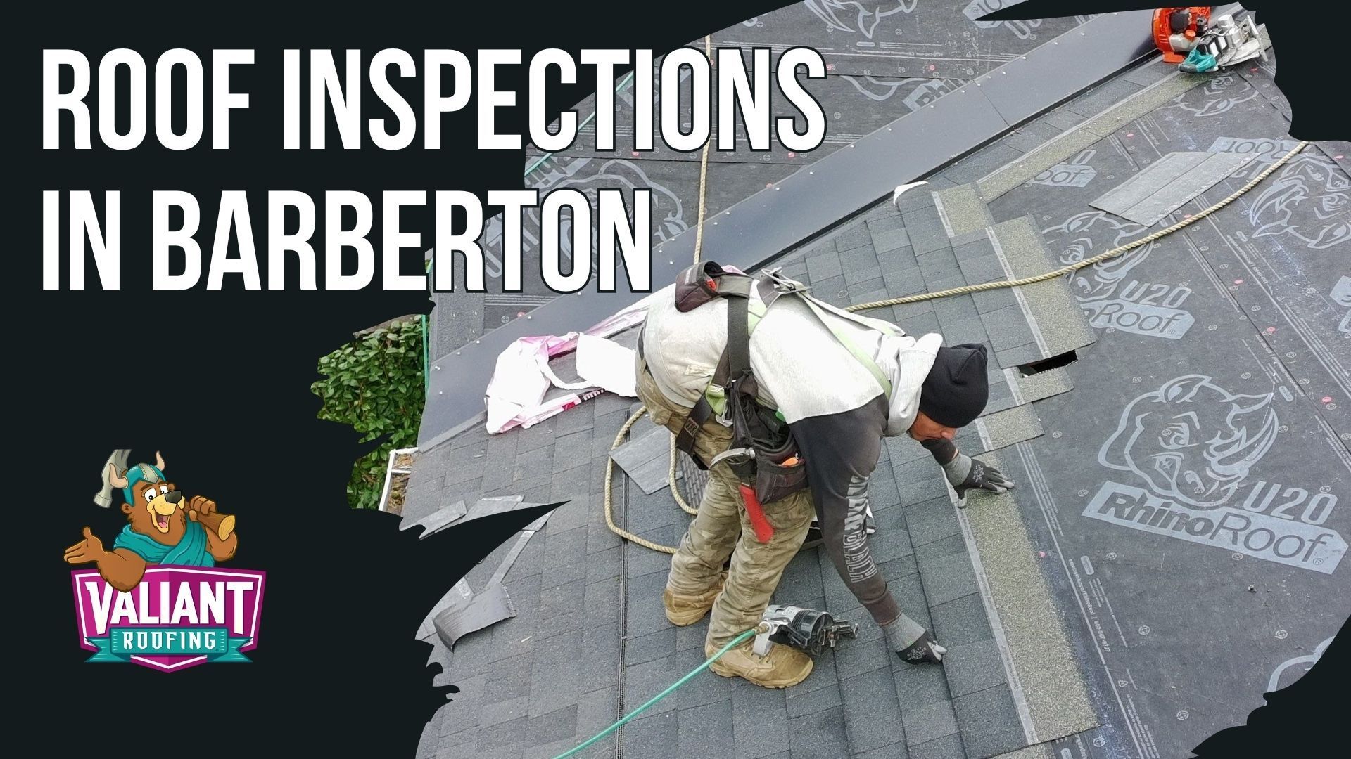 A roof inspector wearing a safety harness works on a shingled roof in Barberton. A Valiant Roofing logo is on the left.