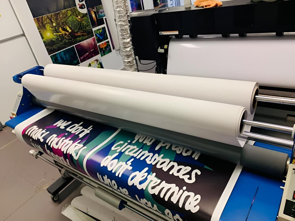 A Large Poster Is Being Rolled Up On A Machine — Cairns Signcorp In Portsmith, QLD