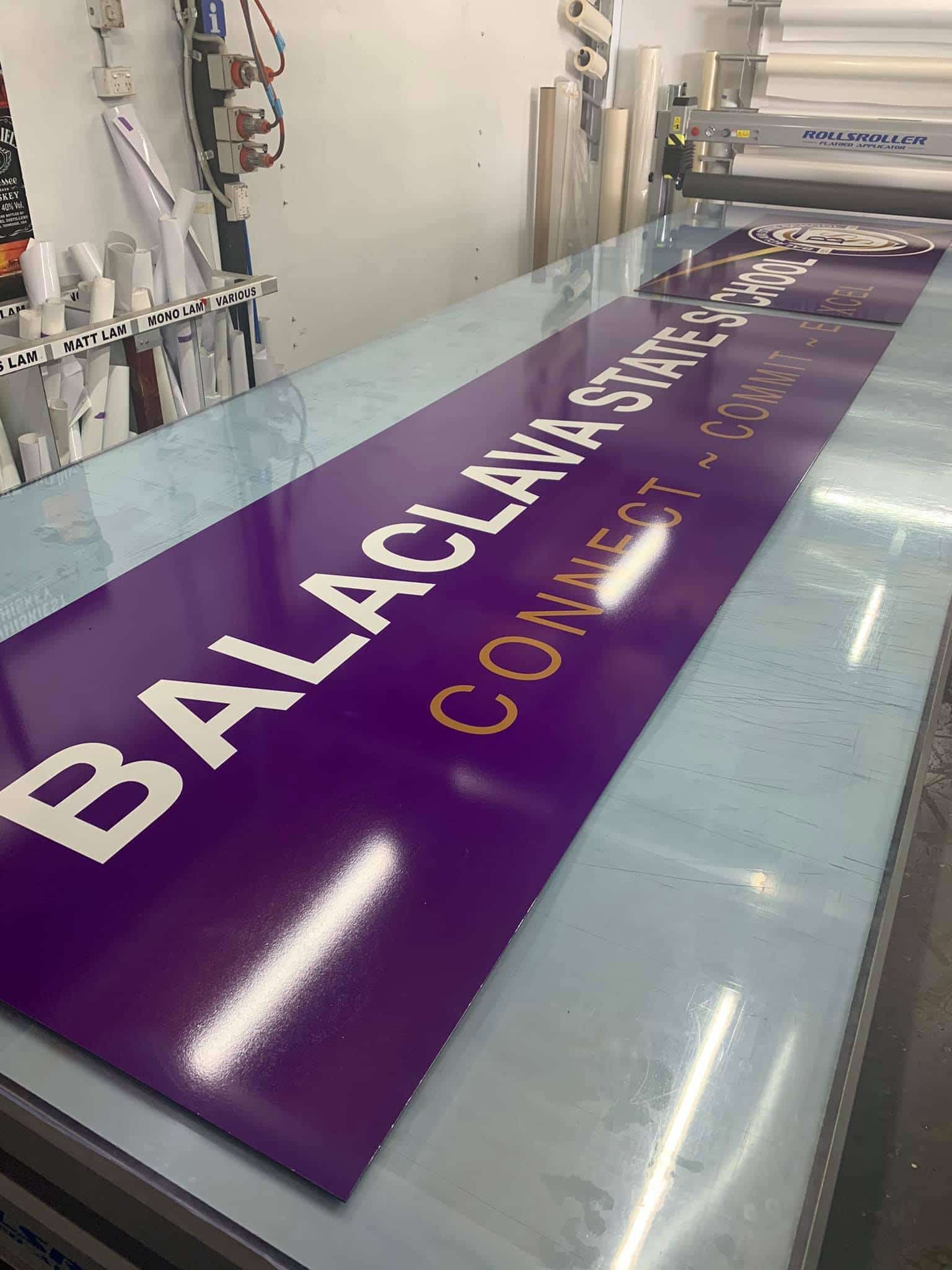 A Large Purple Sign Is Sitting On Top Of A Table — Cairns Signcorp In Portsmith, QLD