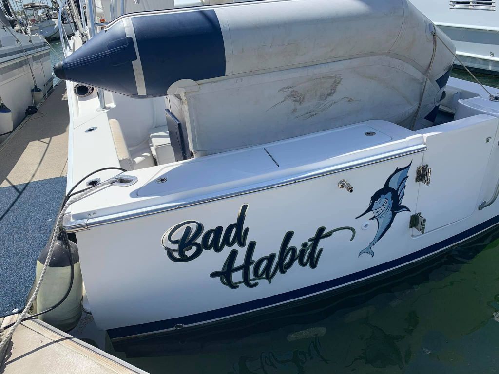 A White Boat With The Words Bad Habit Written On The Side — Cairns Signcorp In Cairns, QLD