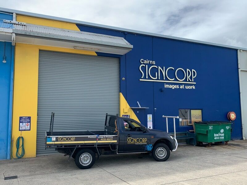 A Truck Is Parked In Front Of A Building That Says Signcorp — Cairns Signcorp In Portsmith, QLD