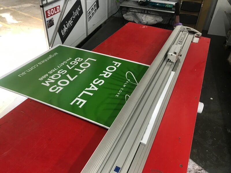 A For Sale Sign Is Sitting On A Red Table — Cairns Signcorp In Portsmith, QLD