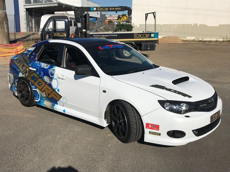 A White Car Is Parked In A Parking Lot Next To A Tow Truck — Cairns Signcorp In Portsmith, QLD