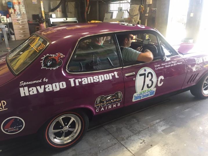 A Man Is Sitting In A Purple Car Sponsored By Havago Transport — Cairns Signcorp In Portsmith, QLD