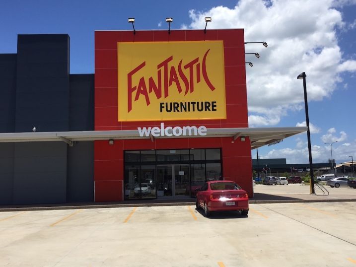 A Red Car Is Parked In Front Of A Fantastic Furniture Store — Cairns Signcorp In Portsmith, QLD