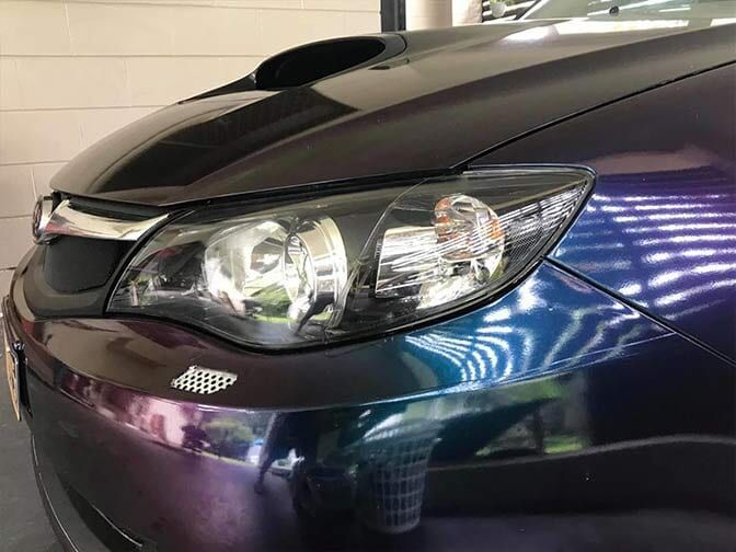 A Close Up Of A Purple Car 's Headlight In A Garage — Cairns Signcorp In Portsmith, QLD