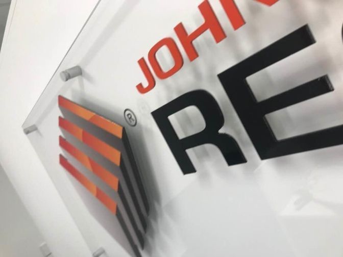 A Close Up Of A John Re Sign On A Wall — Cairns Signcorp In Portsmith, QLD