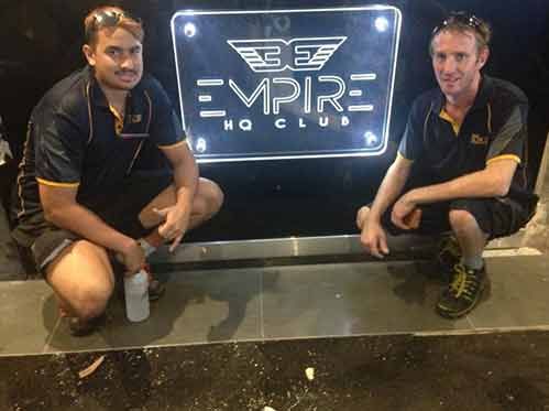 Two Men Are Squatting In Front Of A Sign That Says Empire HQ Club — Cairns Signcorp In Portsmith, QLD