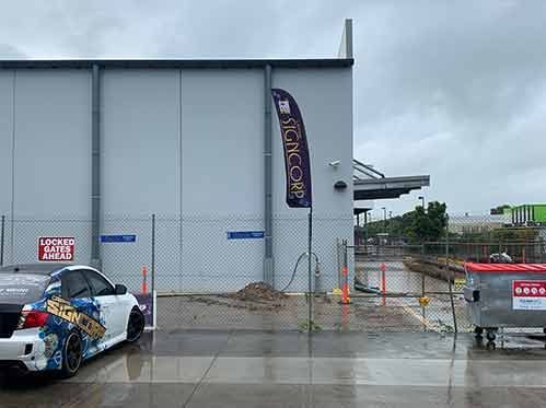 A Car Is Parked In Front Of A Building On A Rainy Day — Cairns Signcorp In Portsmith, QLD