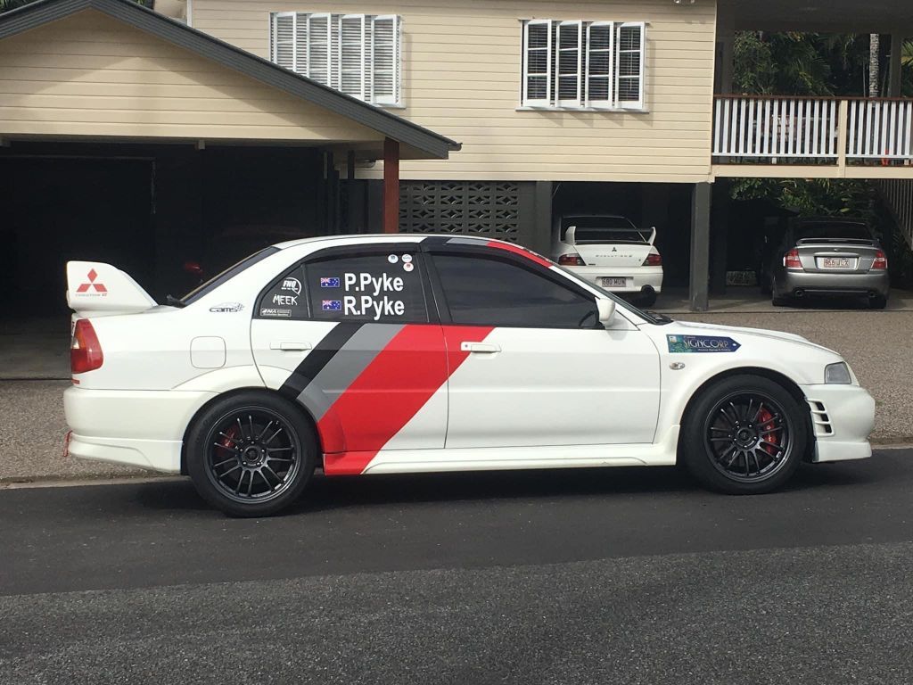 A White Car With Red And Black Stripes Is Parked In Front Of A House — Cairns Signcorp In Portsmith, QLD