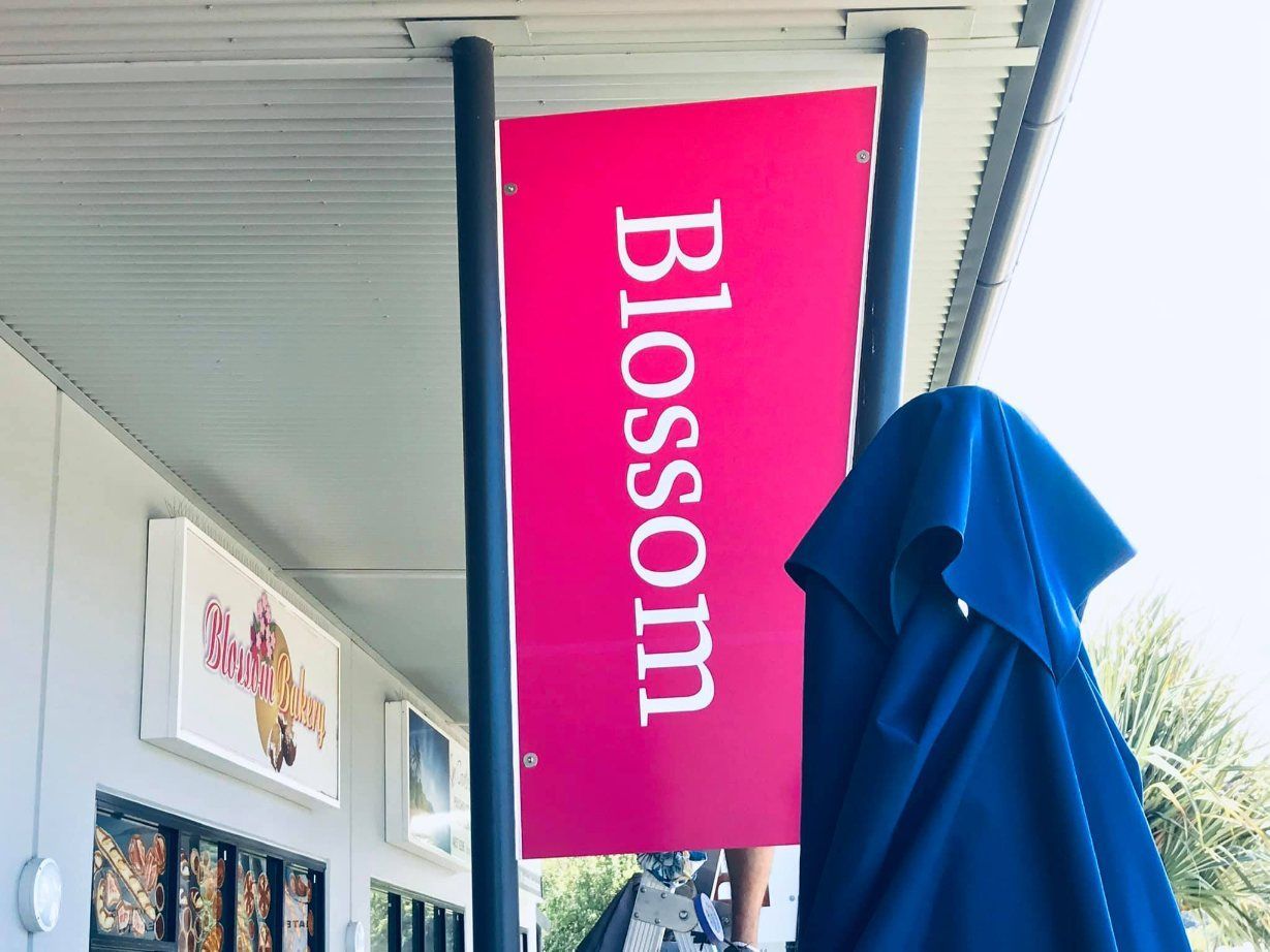 A Pink Sign With The Word Blossom On It — Cairns Signcorp In Mission Beach, QLD