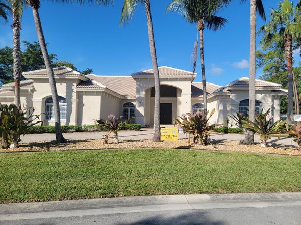 A large white house with palm trees in front of it