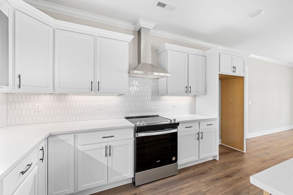 A kitchen with white cabinets and stainless steel appliances.