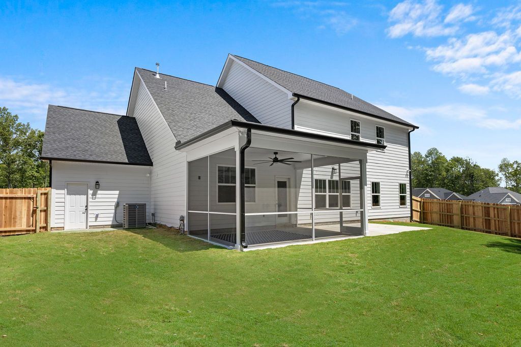 A large white house with a screened in porch in the backyard.