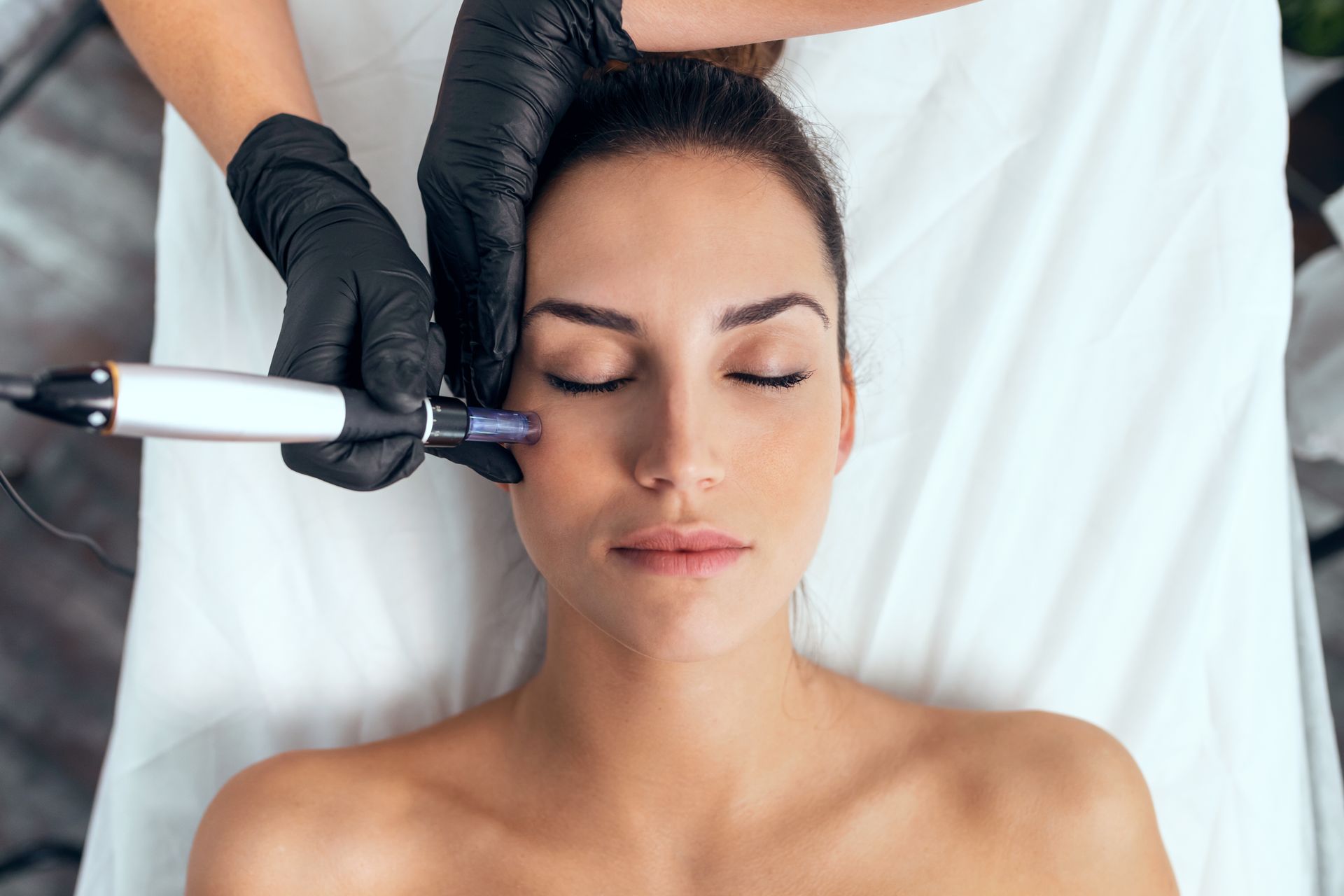 A woman is getting an injection in her face in a beauty salon.
