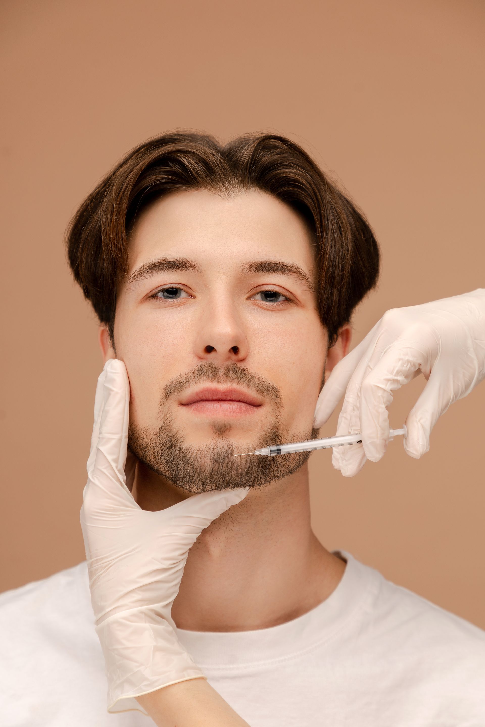 A woman is getting a botox injection in her forehead.