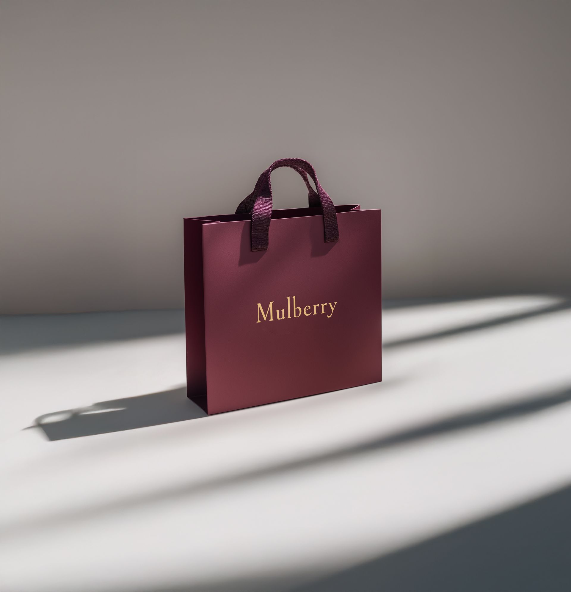 A burgundy mulberry bag sits on a white surface