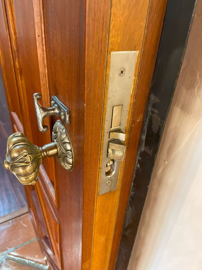 A person is installing a door handle with a drill.