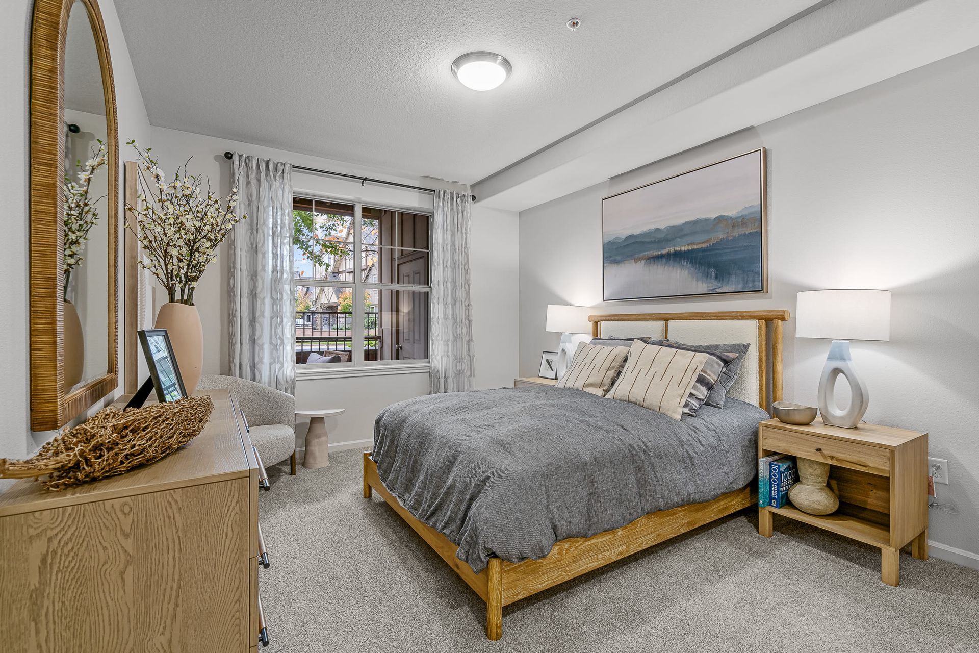 Bedroom in a modern apartment with a wooden bed, nightstands, and a window.