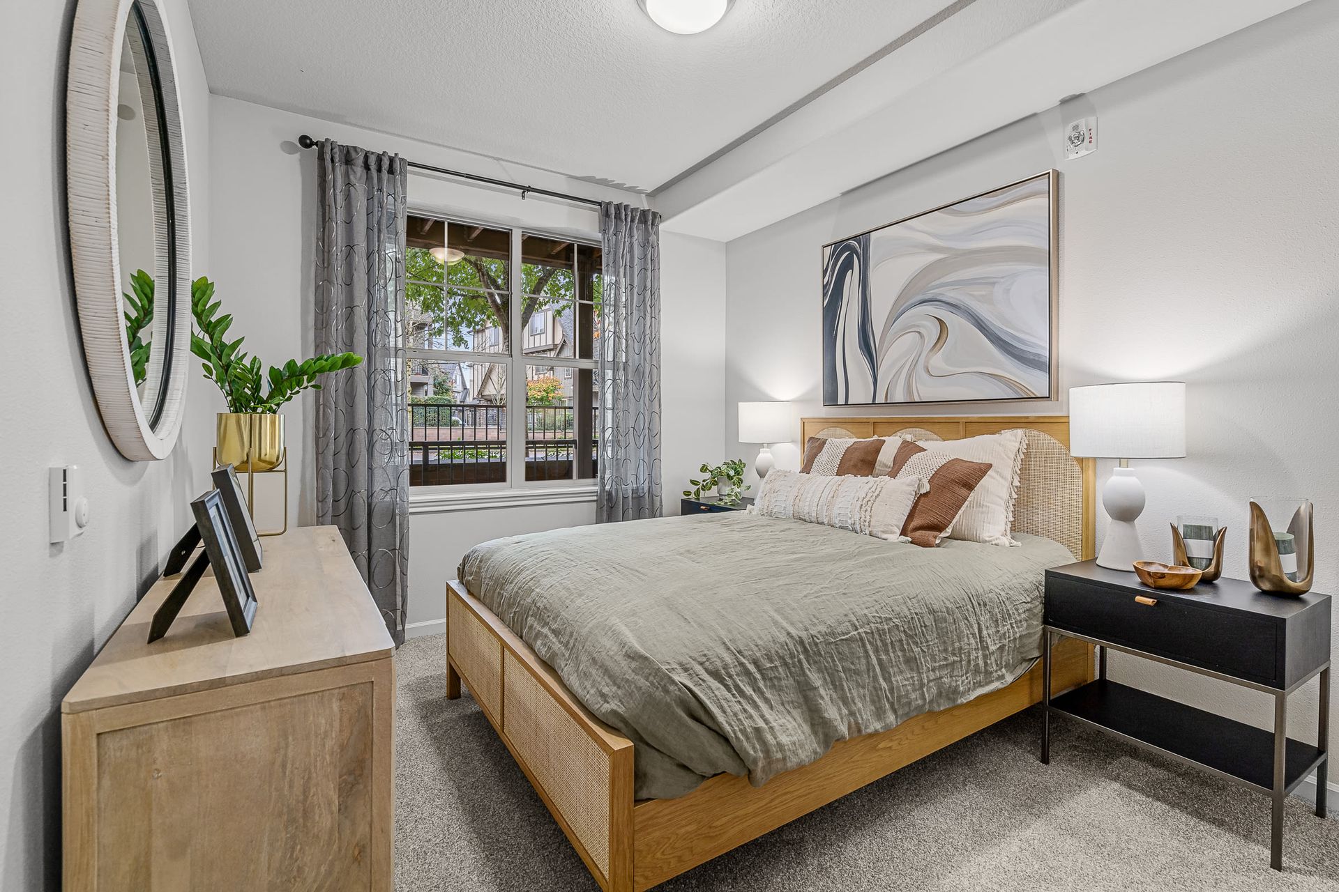 Bedroom in a modern apartment with a wooden bed, two nightstands, and a window with gray curtains.
