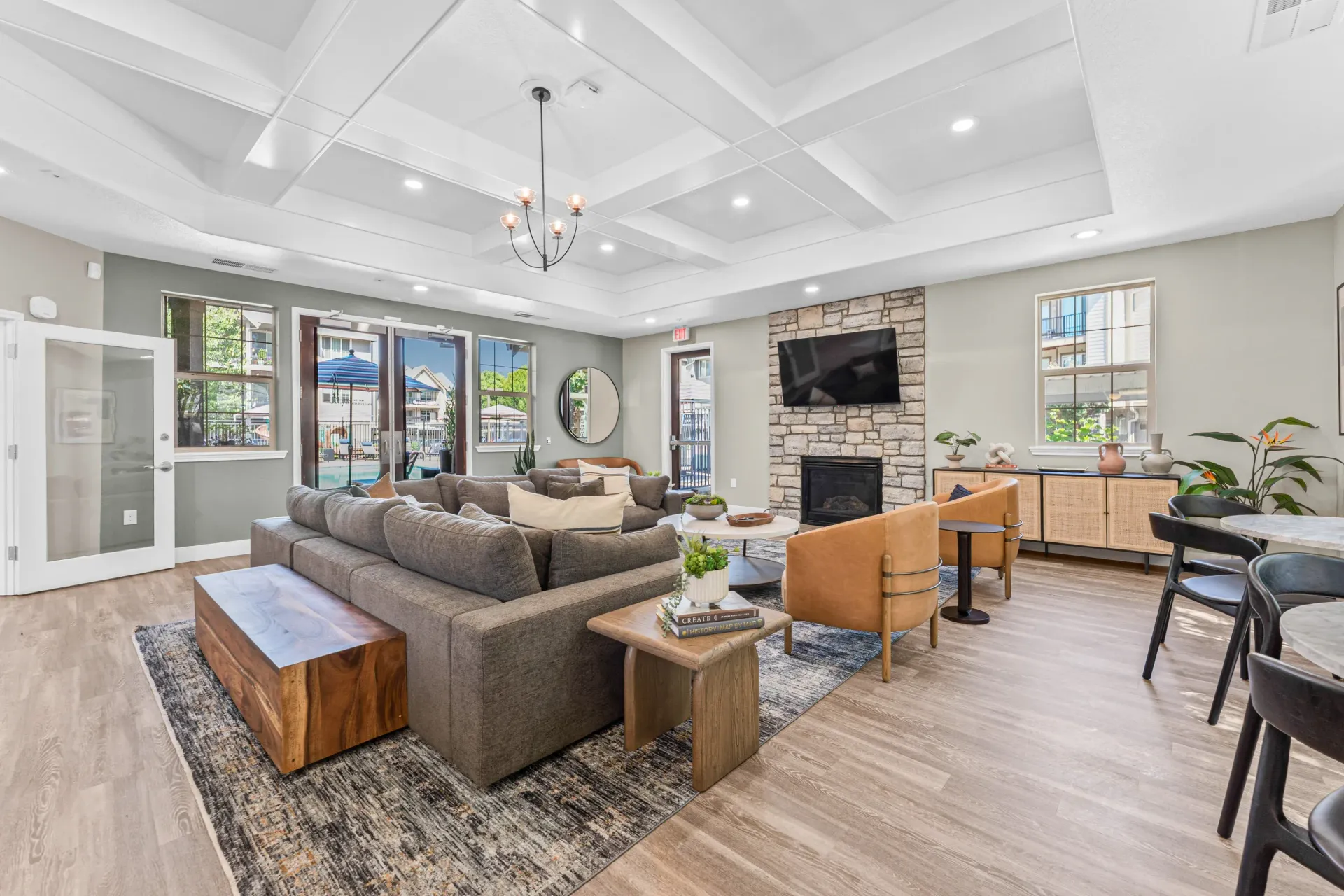 Spacious communal lounge with gray sectional sofa, fireplace, and TV.