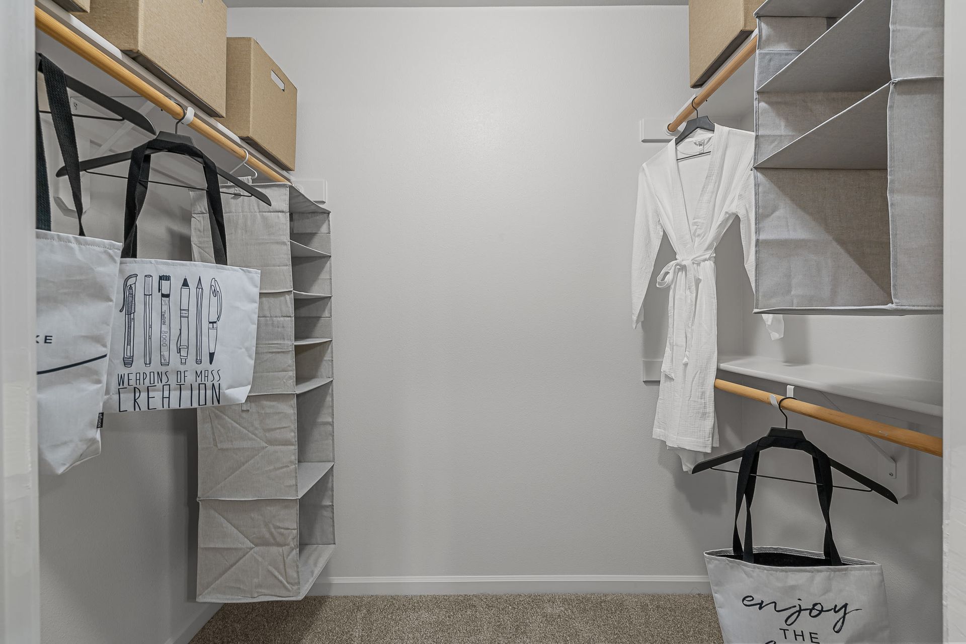 Walk-in closet with shelves, hanging rods, and storage bins.