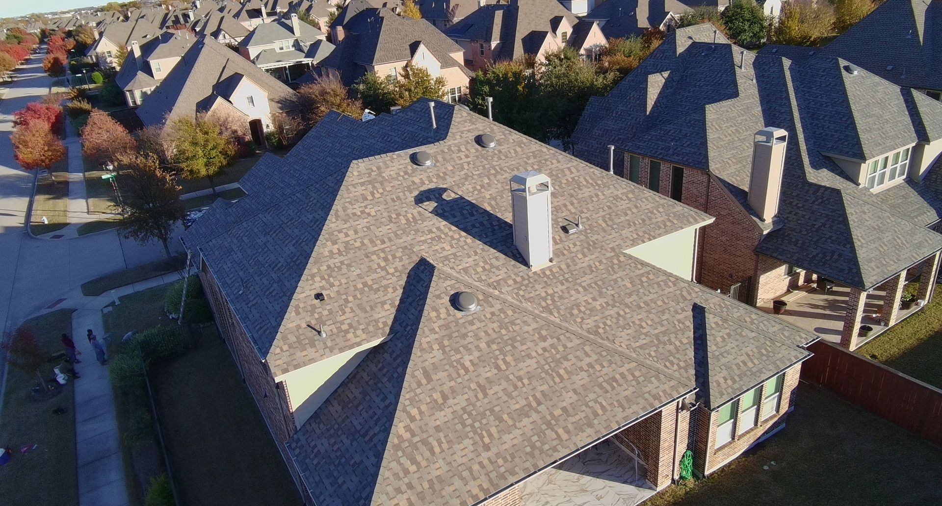 An aerial view of a residential area with a lot of houses and roofs.