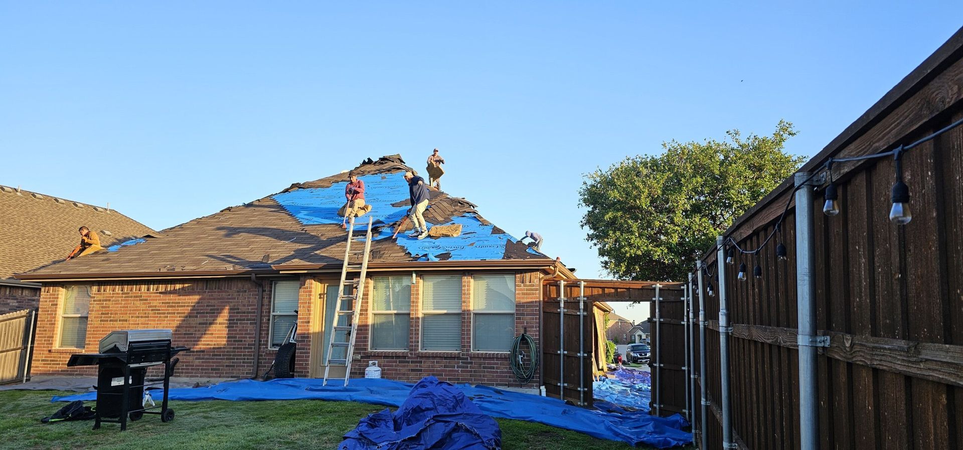 A group of people are working on the roof of a house.