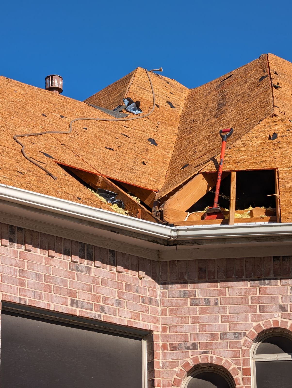 A brick house with a roof that is being repaired