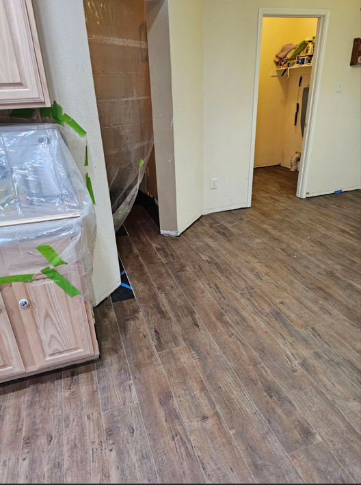 A kitchen with a wooden floor and a sink.