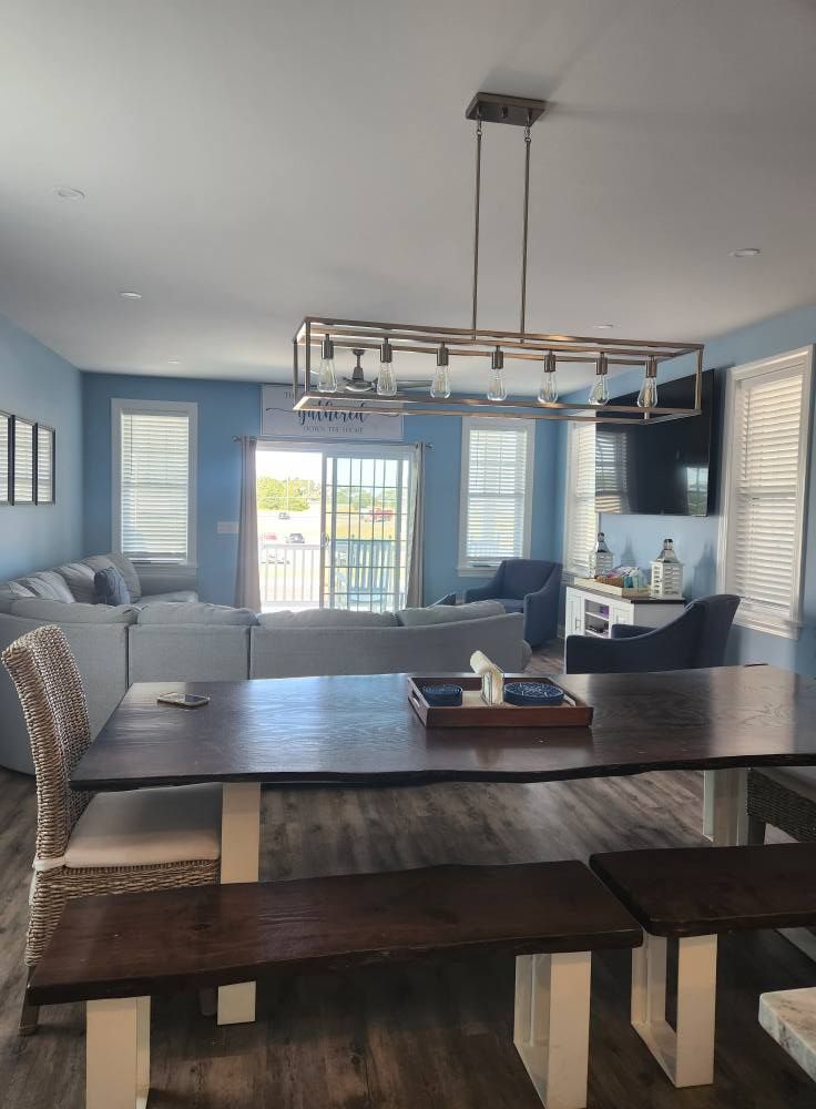Two blue and white ice cream trucks parked outside on a sunny day.