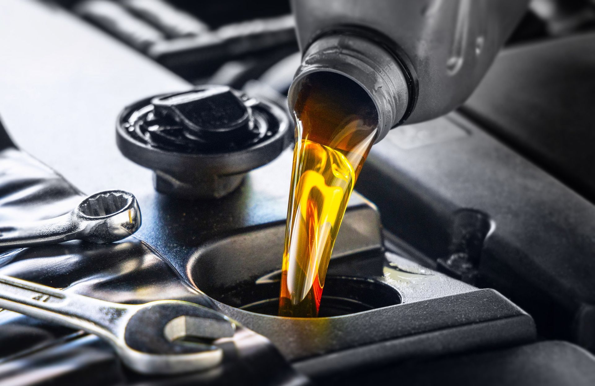 Yellow motor oil being poured into a car engine.