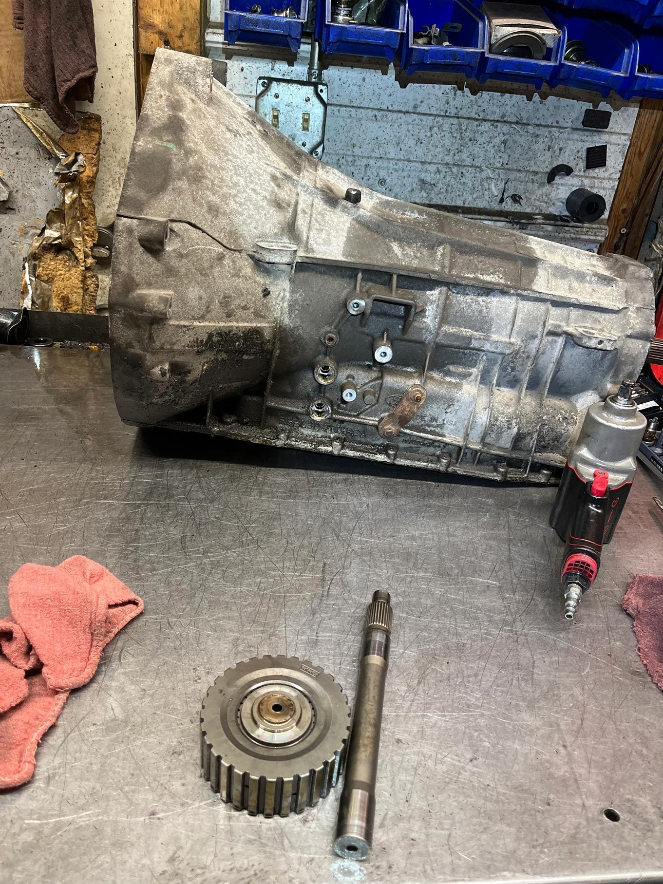 Transmission on a workbench with gears and tools.