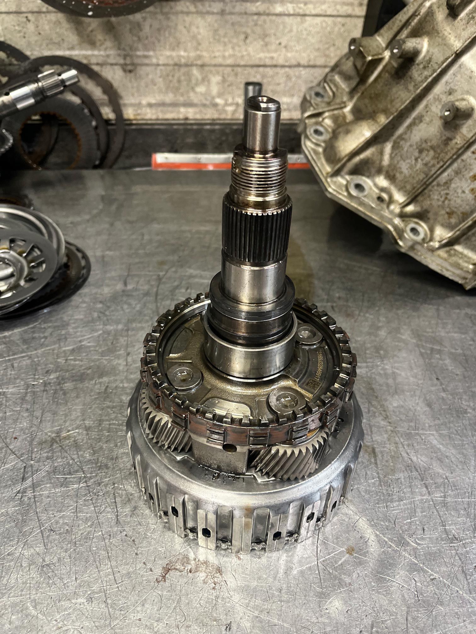 Transmission components on a workbench, including gears and shafts.