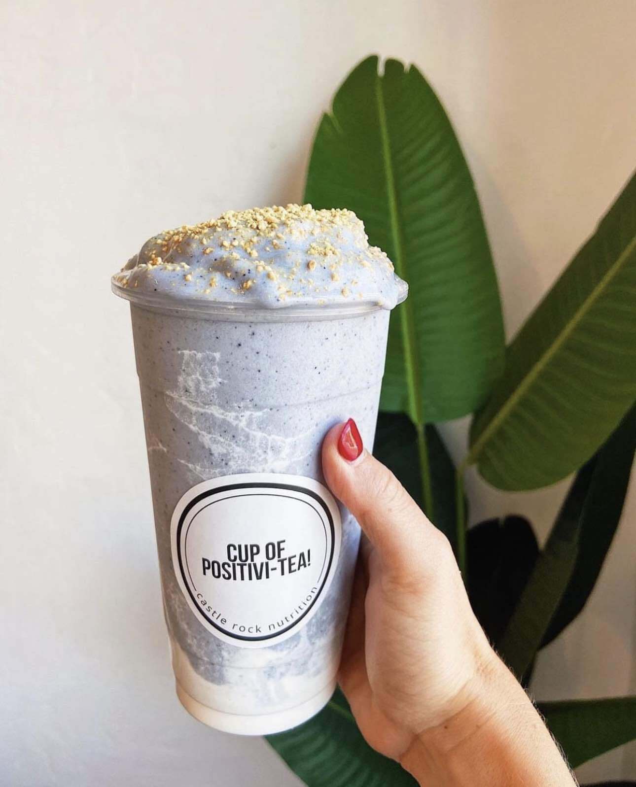 A person is holding a cup of positive tea