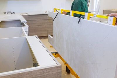 Workers Lifting and Installing with Maple Granite Counter — Oroville, CA — Custom Tile & Granite