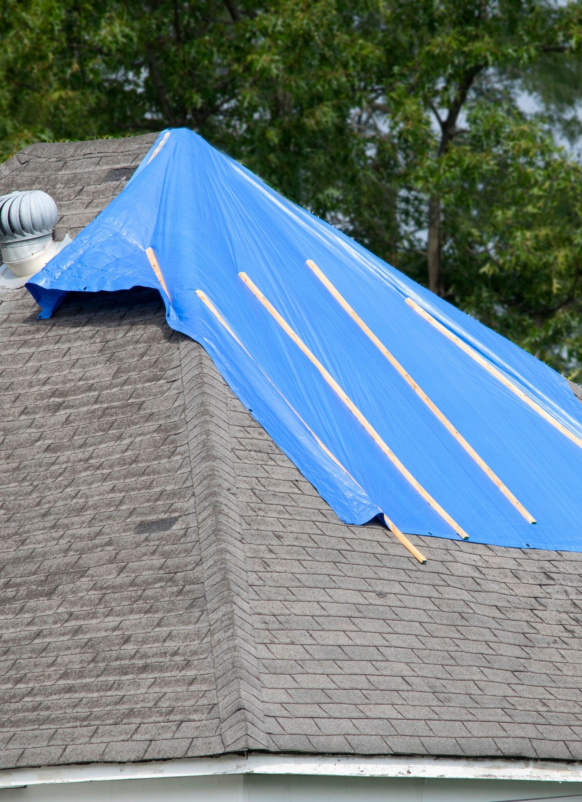 house roof with blue tarp on it
