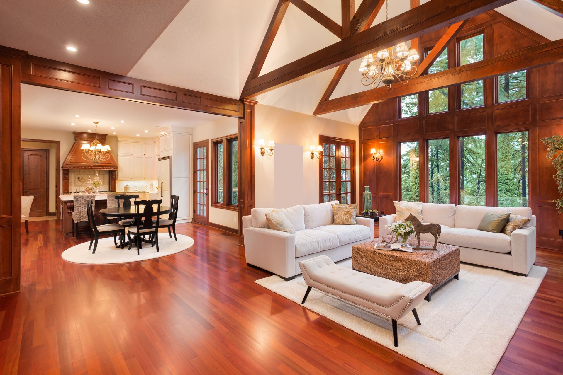 Luxurious living room with hardwood floors, white sofas, and dining area.