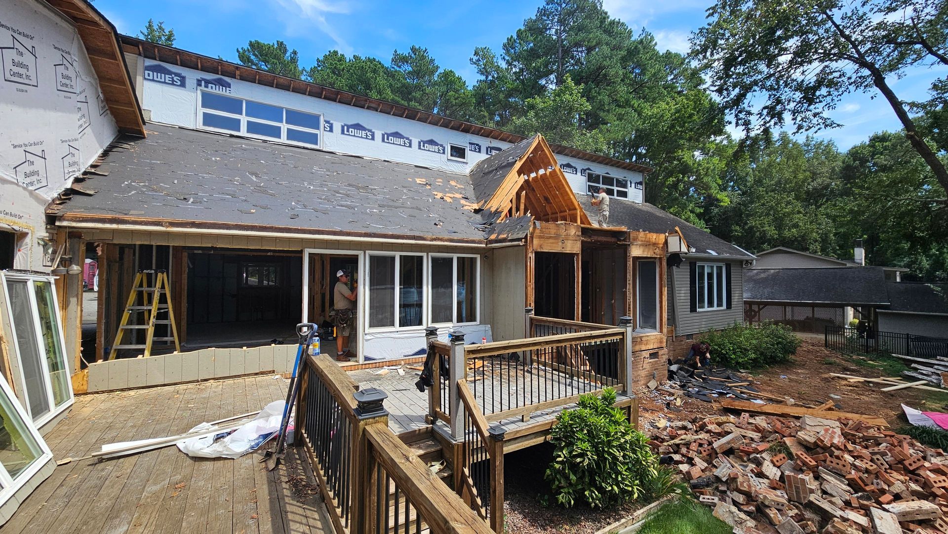 House under renovation with exposed beams, deck, and debris.