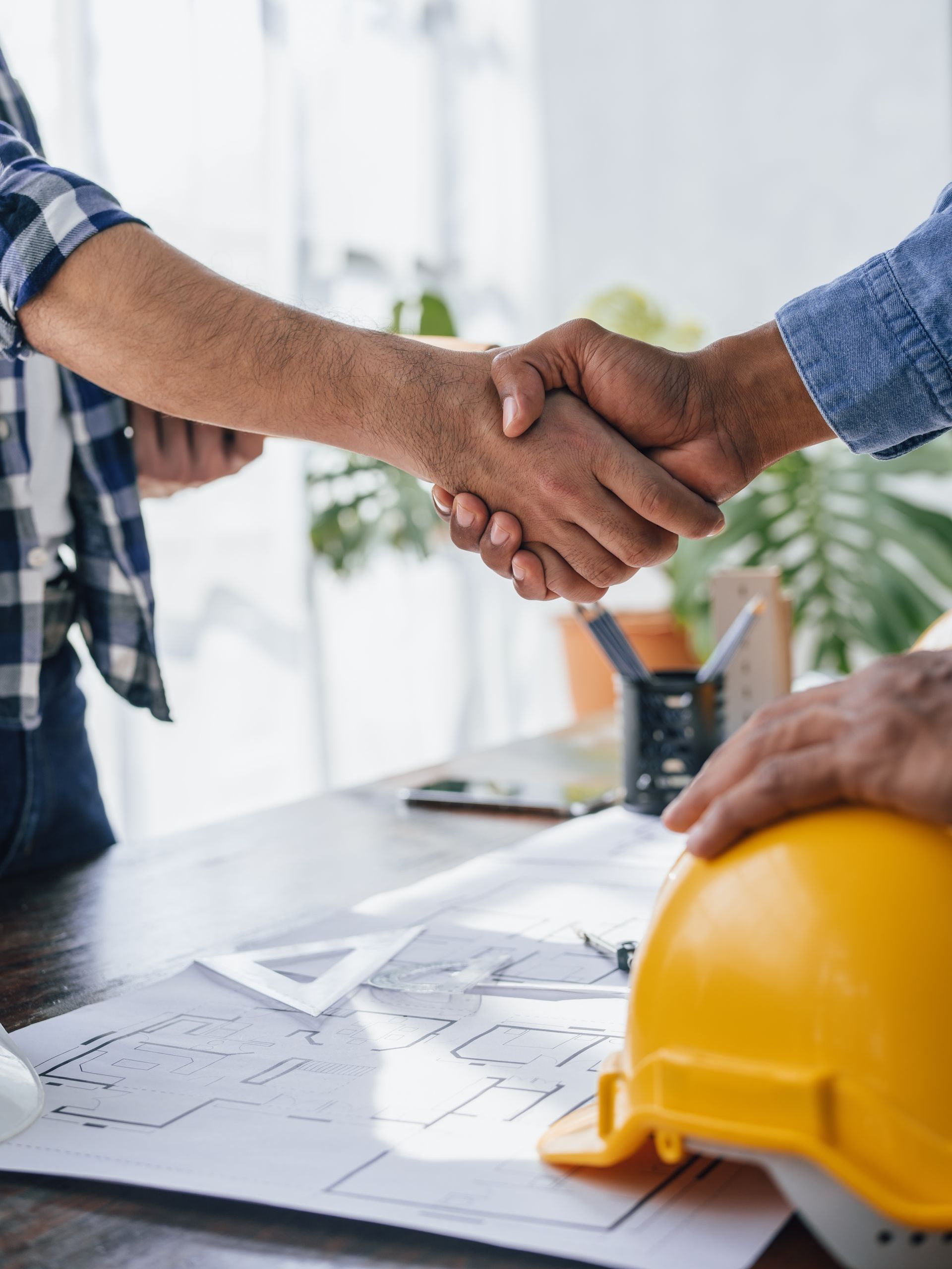 homeowner shaking hands with construction contractor before home building project