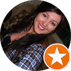 Mulher de cabelos longos e escuros, sorrindo, vestindo uma camisa xadrez; ícone de estrela laranja.