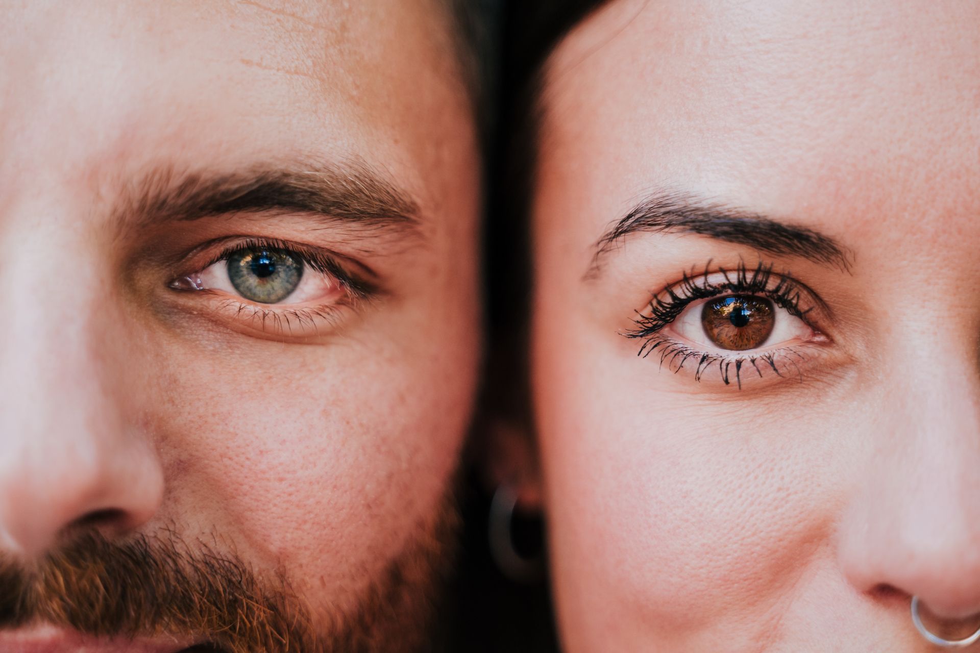 A close-up shot focusing on two individuals' eyes, one blue and one brown, set side-by-side.