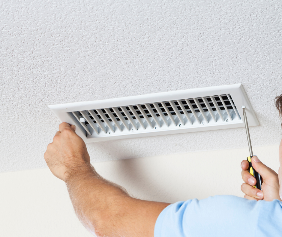 HVAC technician conducting duct system installation and repair on ceiling vent