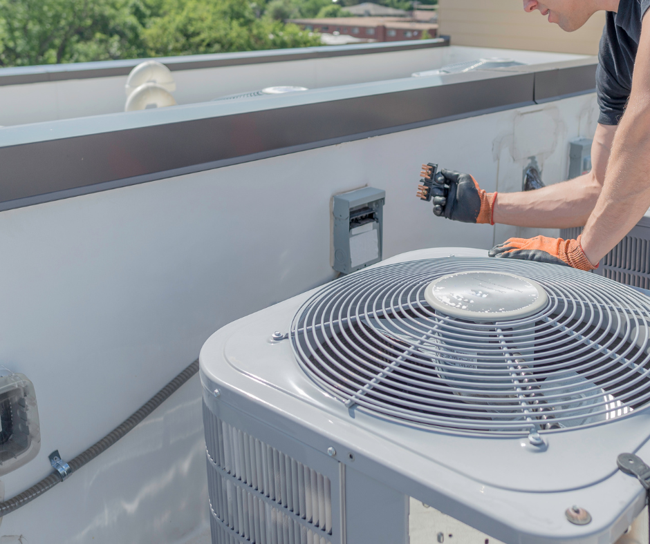 HVAC technician performing rooftop HVAC installation and replacement services