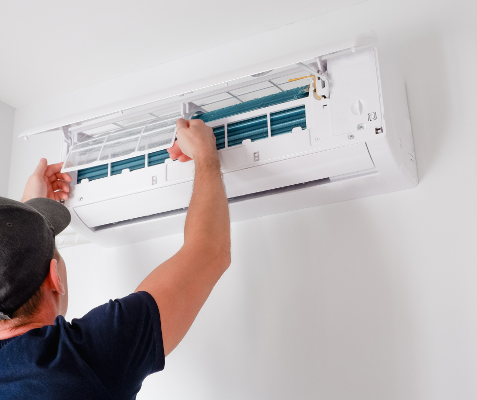 HVAC technician performing ductless system repair and air filtration system cleaning